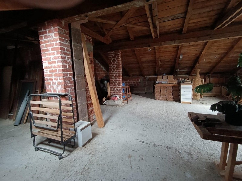 Podkrovní pokoj s odhalenými dřevěnými trámy a cihlami v činžovním domě na prodej v Crikvenici, Chorvatsko.