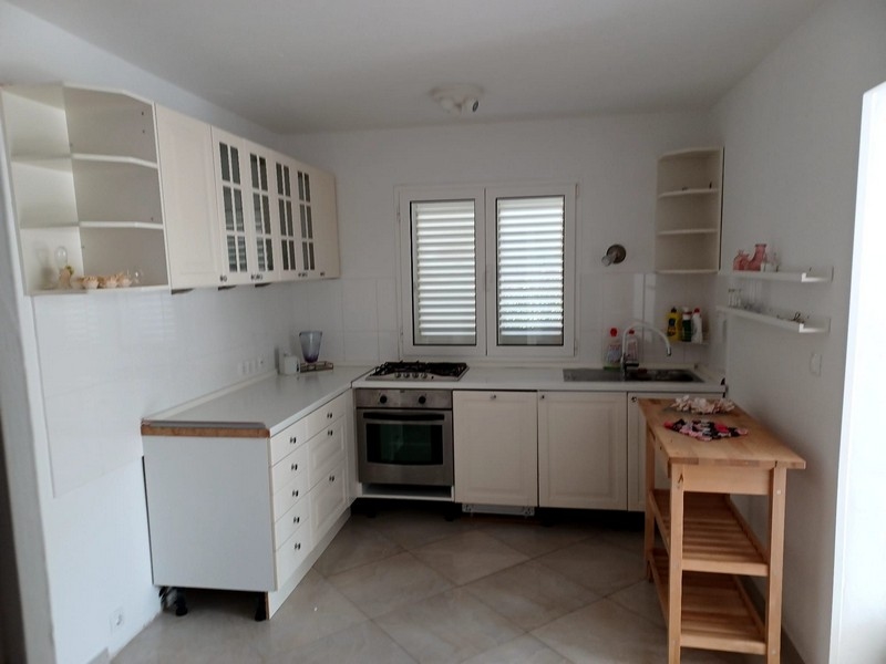 Moderní, světlá kuchyně s bílými skříňkami a spotřebiči ve vile na prodej na ostrově Cres v Chorvatsku