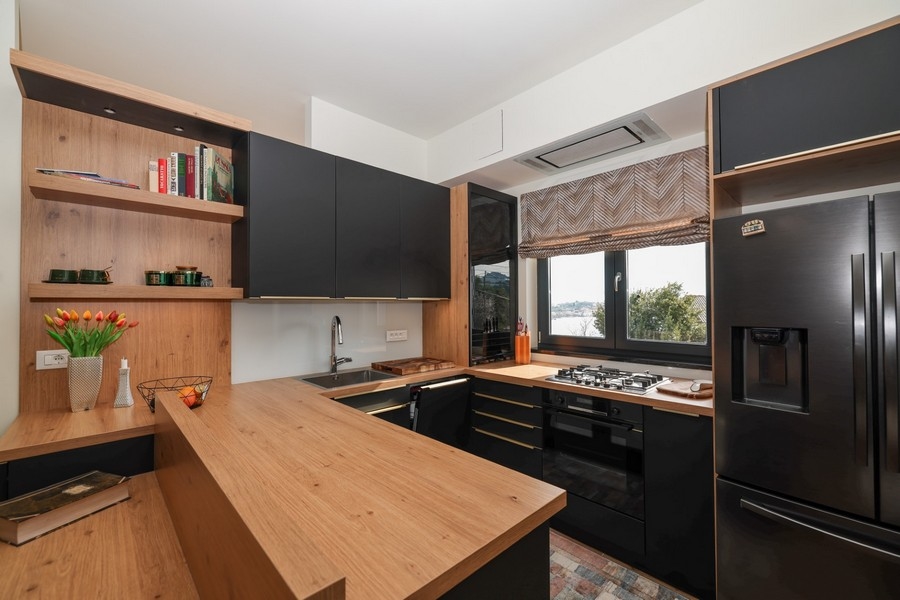 Vnitřní pohled na moderní kuchyni ve vile na prodej na Ugljanu, s dřevěnými akcenty a výhledem na moře.