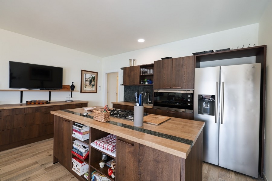 Druhá kuchyňská linka s dřevěnými čely skříněk a moderními spotřebiči ve vile na prodej na ostrově Ugljan