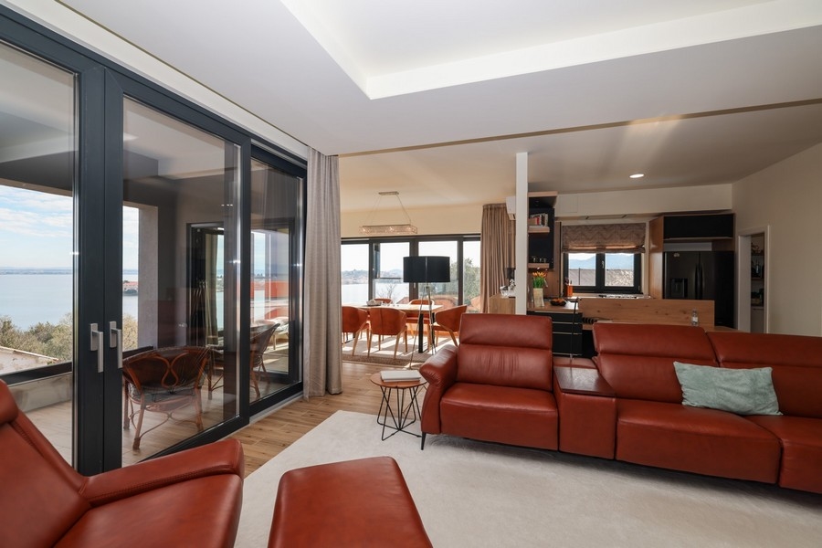 Obývací pokoj s koženou pohovkou ve tvaru L a otevřeným přechodem do kuchyně ve vile na Ugljanu, která je na prodej