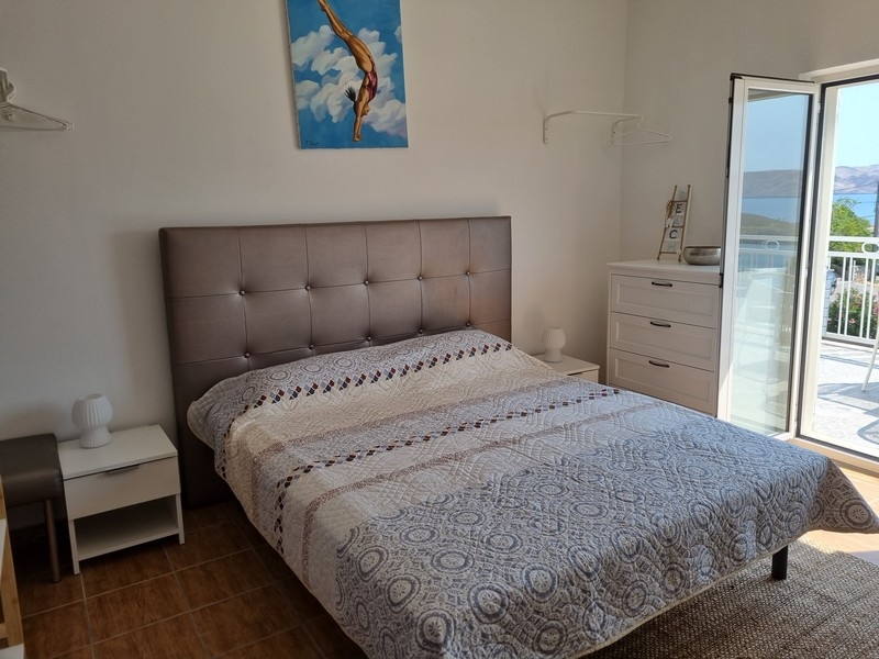 Dvoulůžkový pokoj s uměleckým dílem na stěně v činžovním domě na prodej v Karlobagu, Chorvatsko.