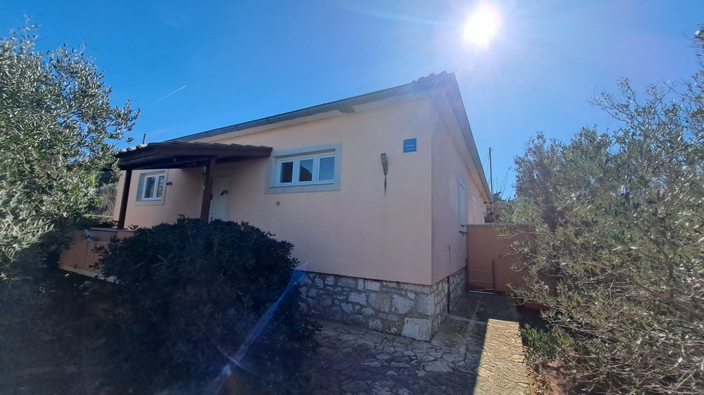 Pohled na stranu domu obklopeného středomořskými rostlinami, přímořská nemovitost v Chorvatsku