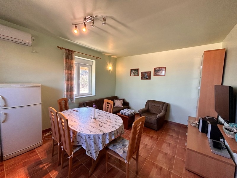 Obývací pokoj s jídelním stolem a kuchyňským vybavením, uvnitř části přímořské nemovitosti v Chorvatsku