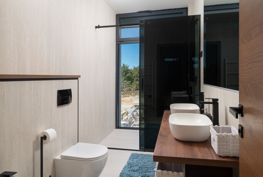 Stylová koupelna s výhledem na moře v prodejní vile v Ražanac, region Zadar, Chorvatsko, vybavená závěsným WC a moderním umyvadlem na dřevěné spodní skříňce.