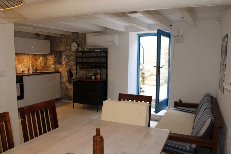 Vnitřní pohled na kamenný dům v Murteru, obývací pokoj a jídelní kout.