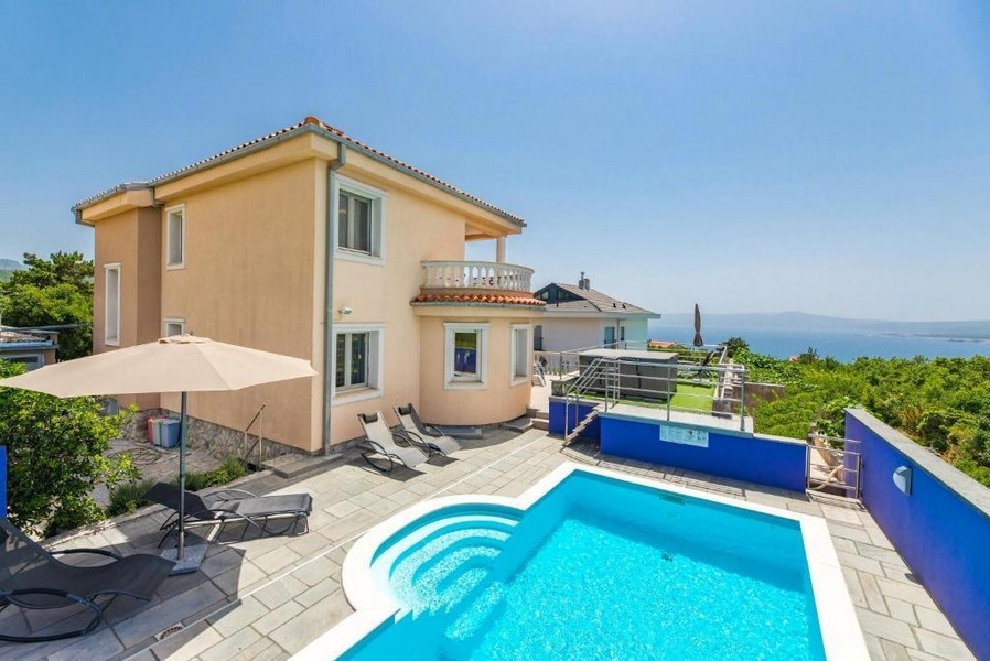 Dvorek činžovního domu v Chorvatsku s bazénem a lehátky, výhled na moře