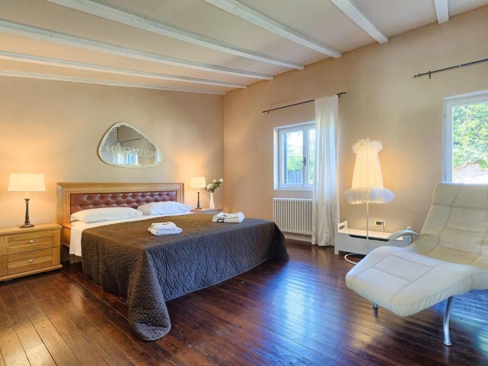 Velká ložnice s dřevěnými podlahami a moderním komfortem, aspekt luxusních nemovitostí v Chorvatsku