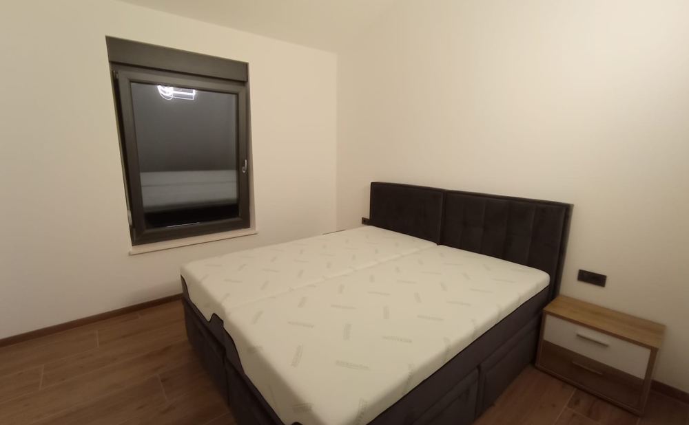 Jednoduchá ložnice s manželskou postelí v nemovitosti v Chorvatsku, noční okno zavřené.