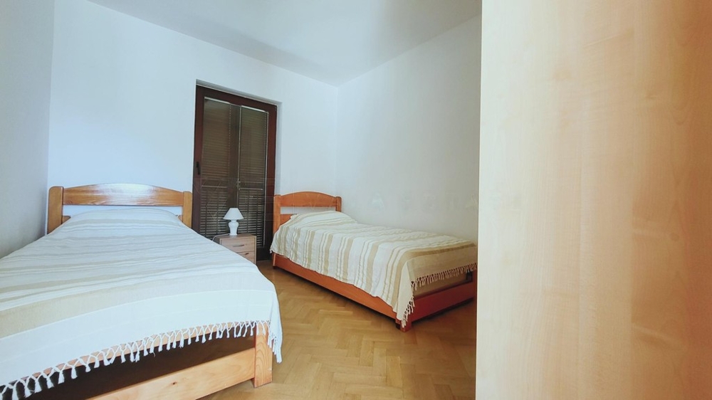 Ložnice se dvěma postelemi a parketovou podlahou