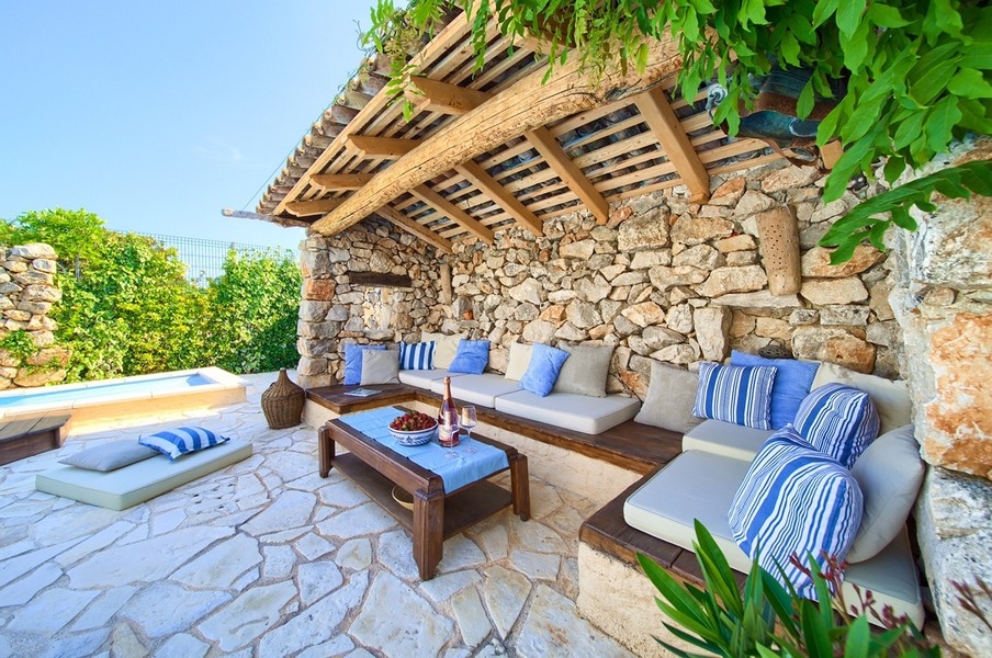 Kryté venkovní posezení s pohodlnými polštáři a výhledem na bazén, typické pro nemovitost na ostrově Krk.