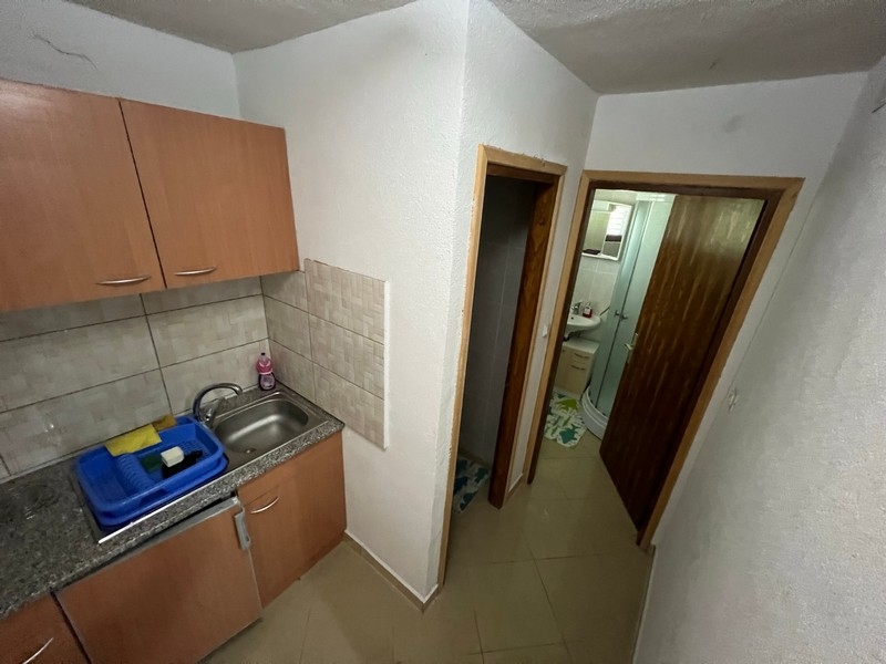 Malá kuchyně s přilehlou chodbou v nemovitosti na ostrově Krk, ukazuje minimalistický styl.