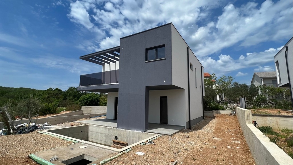 Nemovitosti Chorvatsko, město Krk, ostrov Krk Vila na prodej - boční pohled na moderní vilu s betonovým základem a okolní krajinu