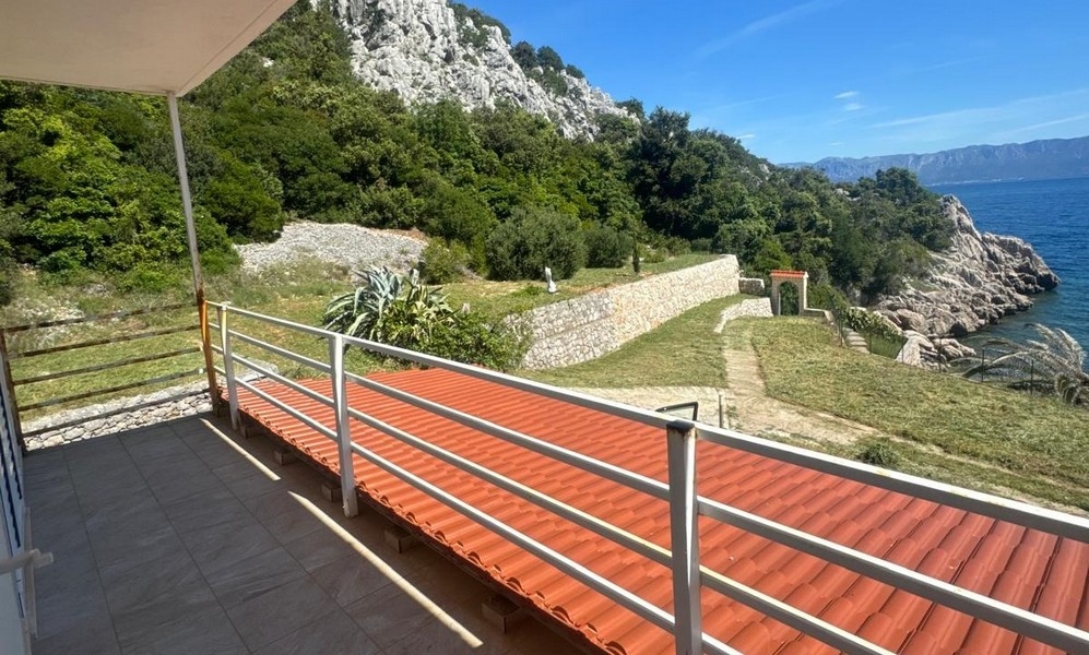 Vila s bílou fasádou obklopená středomořskou vegetací a kamenným obloukem, poloostrov Pelješac