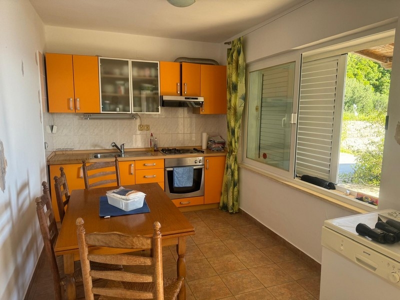 Prostorný obývací pokoj se žlutými pohovkami a dekorativními malbami v přímořské vile na poloostrově Pelješac