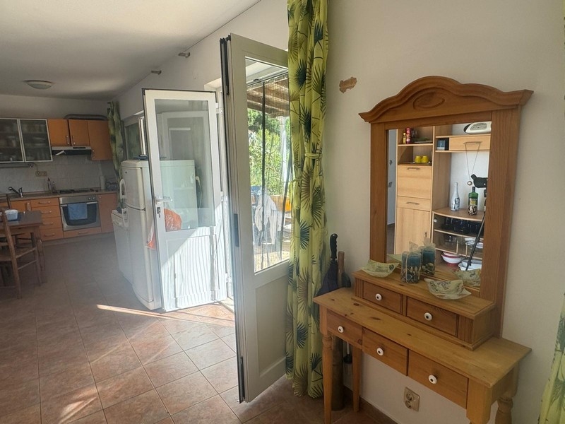 Pohled přes prosklené dveře na terasu přímořské vily s kuchyňským koutem, poloostrov Pelješac