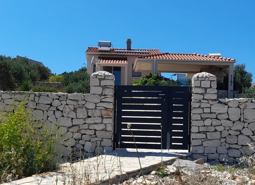 Moderní kuchyně s bílými skříňkami a malým oknem.