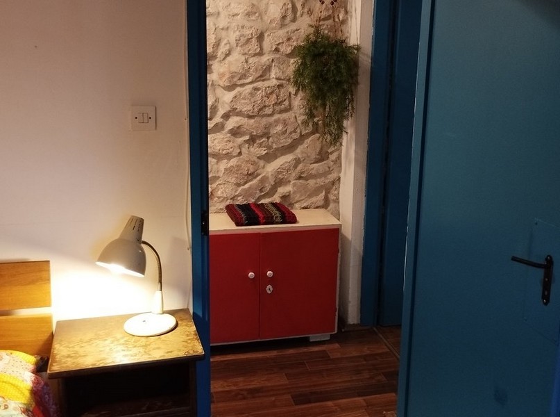 Ložnice s kamennými zdmi a rustikálním kouzlem, ideální pro koupi domu v Chorvatsku.