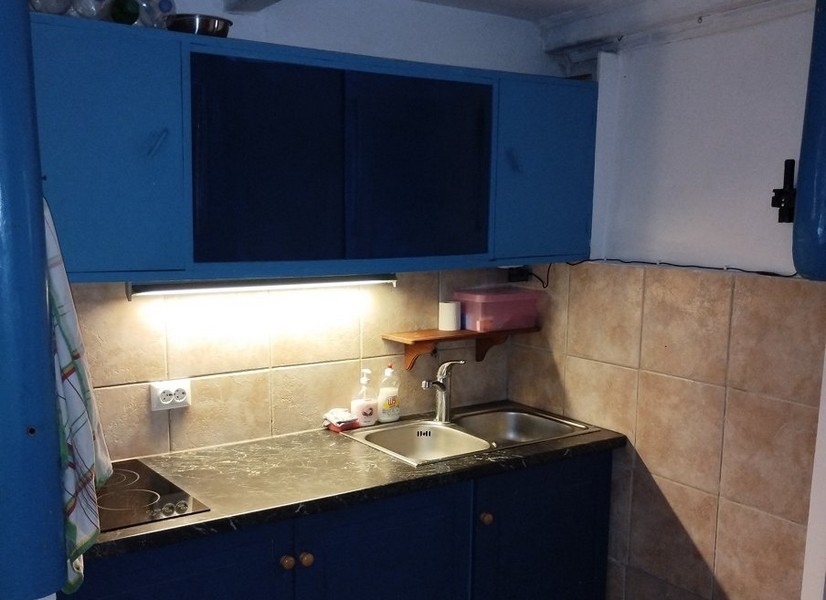 Kompaktní kuchyně s modrými skříňkami, ideální pro ty, kteří si chtějí koupit dům v Chorvatsku.