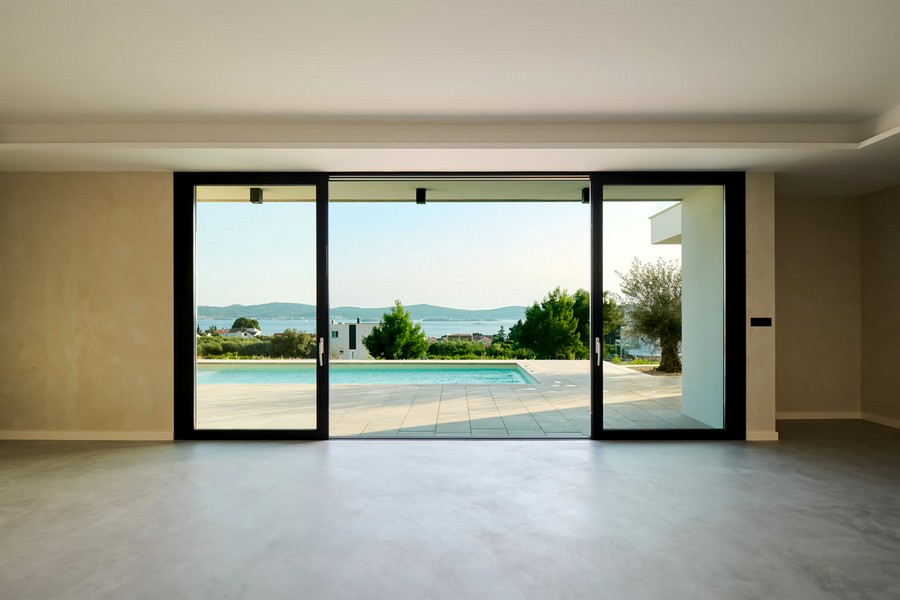 Obývací pokoj s výhledem na moře a bazén.