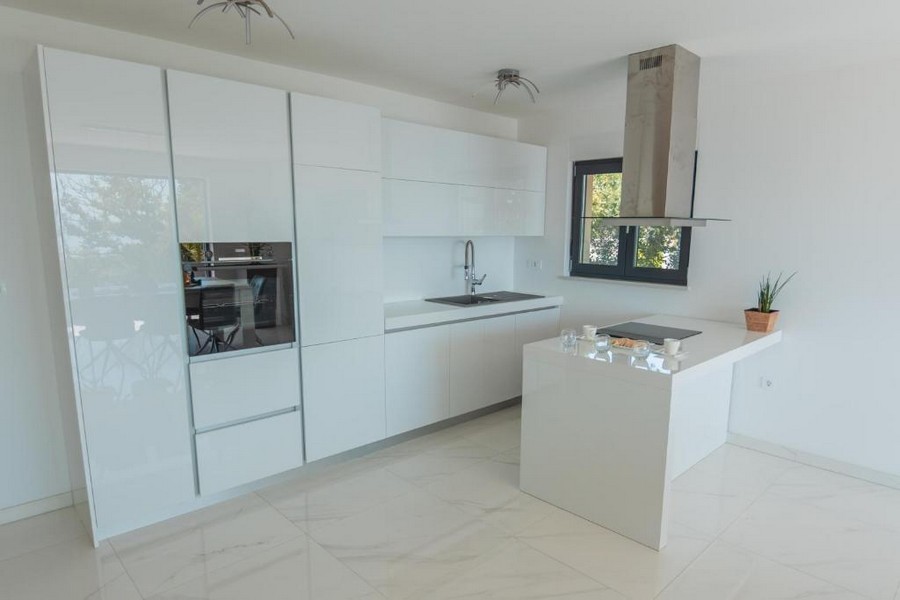 Moderní kuchyně s bílými skříňkami a středovým ostrůvkem