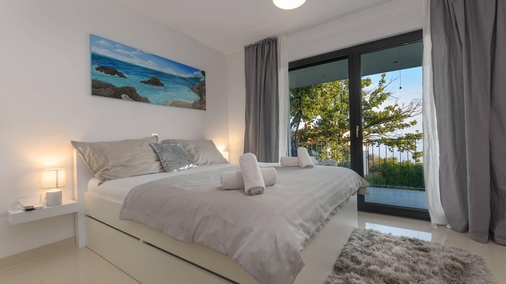 Útulná ložnice s balkonem a výhledem do svěží zeleně