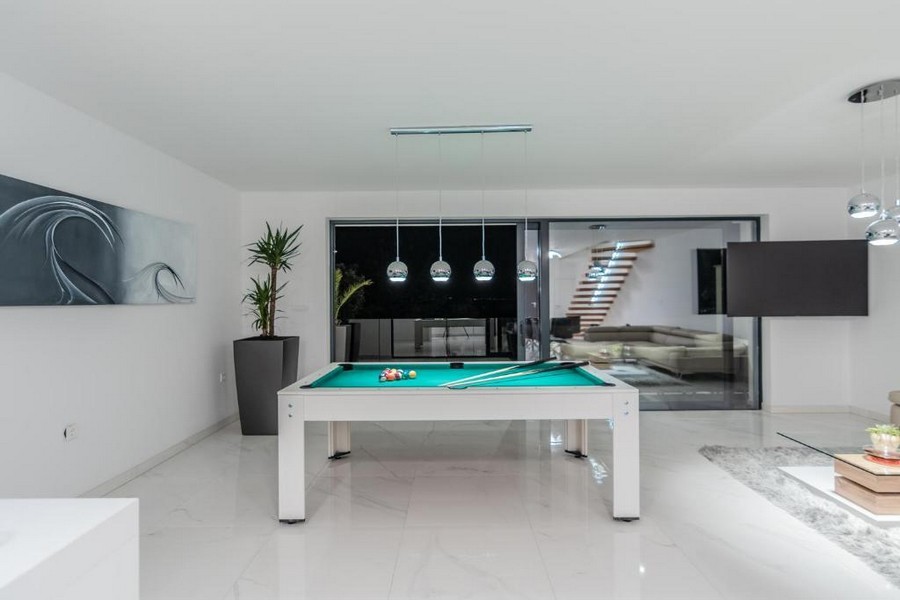 Volnočasová místnost s kulečníkovým stolem a stylovými svítidly