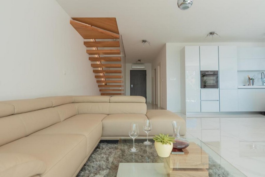 Stylový obývací pokoj s otevřenou kuchyní a schodištěm