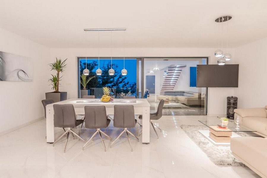 Elegantní jídelní kout s moderním nábytkem a večerním osvětlením