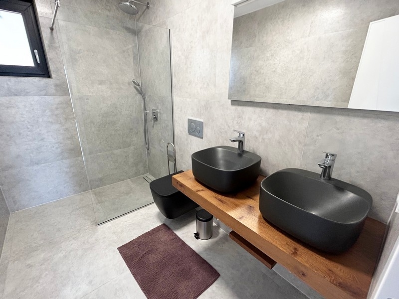 Moderní vila koupelna s dvojitými umyvadly a sprchovým koutem