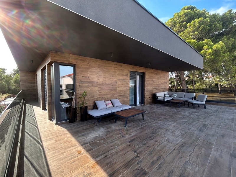 Velká terasa vily s posezením a výhledem na okolní stromy