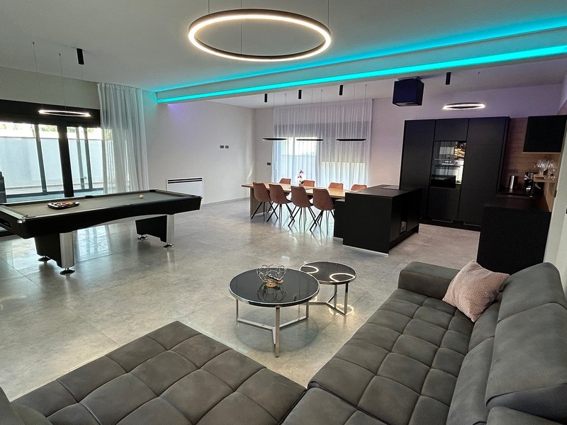 Obývací pokoj s kulečníkem, jídelním koutem a moderním osvětlením