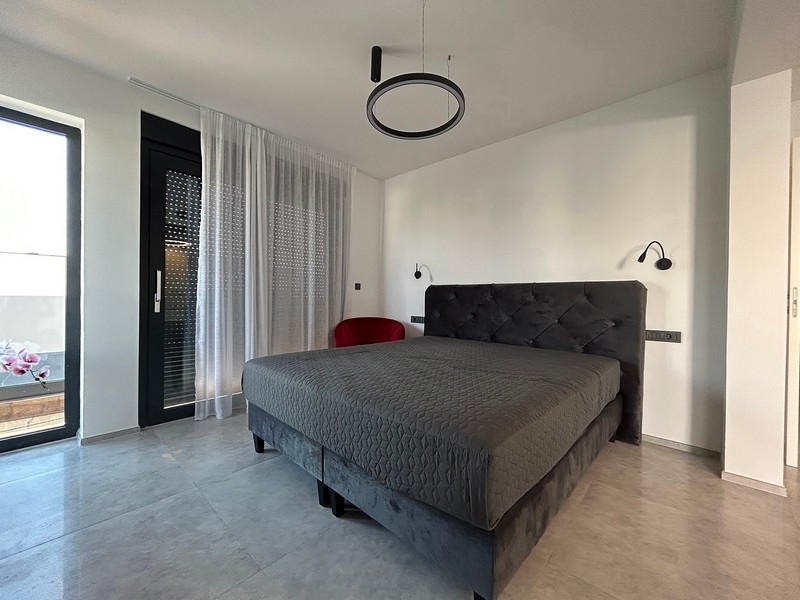 Ložnice s přímým vstupem na terasu a minimalistickým nábytkem