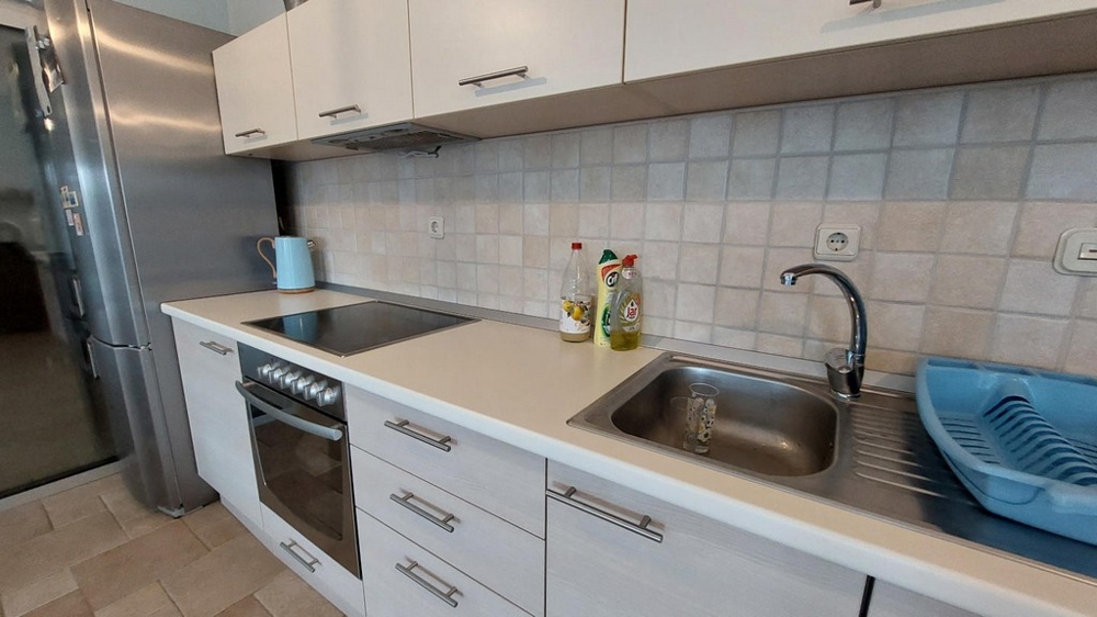 Moderní kuchyně se sporákem, dřezem a lednicí v domě v Chorvatsku