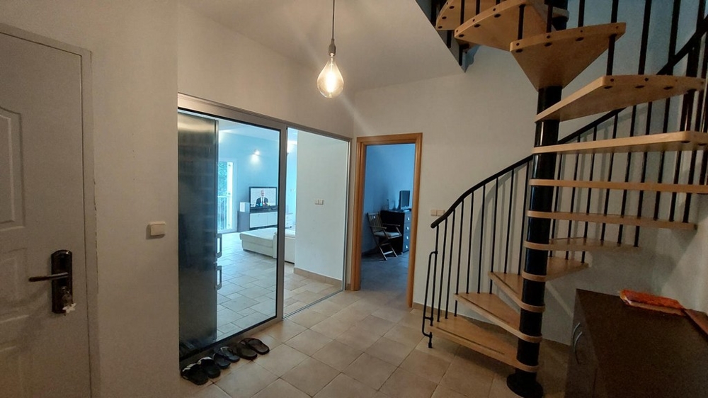 Vstupní prostor s točitým schodištěm a výhledem do obývacího pokoje v domě v Chorvatsku