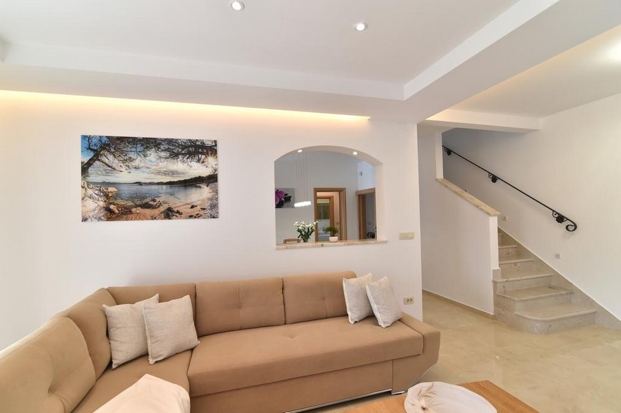 Útulný obývací pokoj s pohovkou a schodištěm