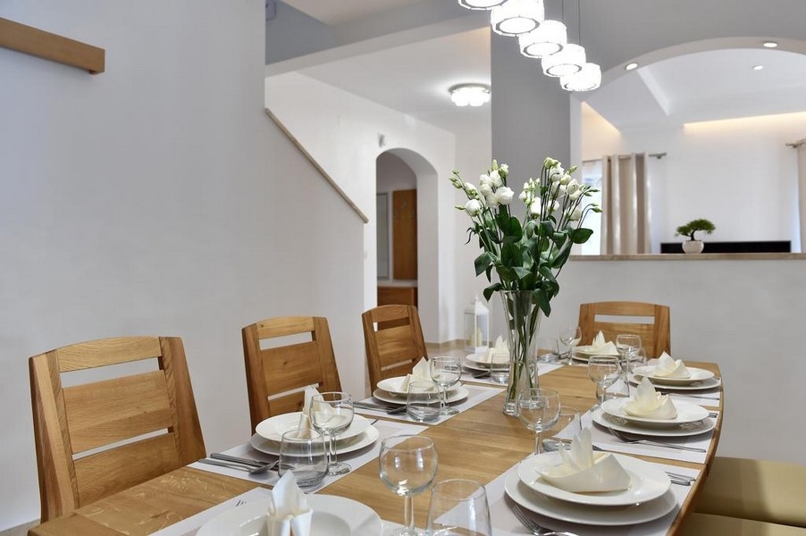 Elegantní jídelní kout s prostřeným stolem a květinovým aranžmá