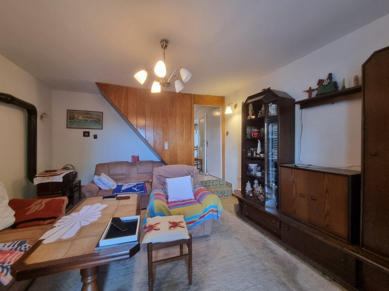 Útulný obývací pokoj s dřevěným nábytkem a kobercem v domě v Sveti Juraj, Chorvatsko