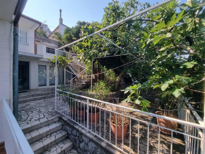 Zahrada se schody a hrnkovými rostlinami v domě