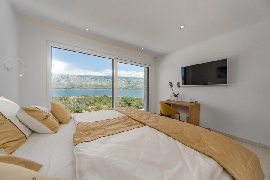 Ložnice s panoramatickým oknem a výhledem na moře