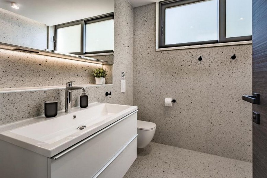 Moderní koupelna s velkým umyvadlem a oknem