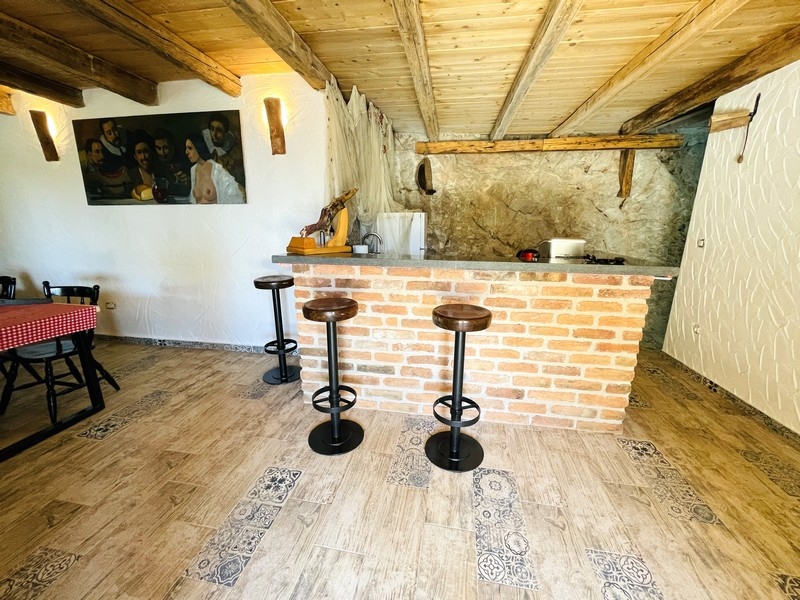 Rustikální krčma s zděným barem, dřevěným trámovým stropem a barovými židlemi