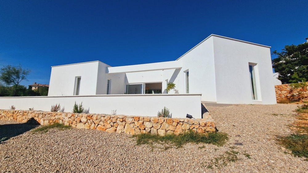 Moderní jednopatrová vila v Chorvatsku s bílou fasádou a štěrkovou cestou