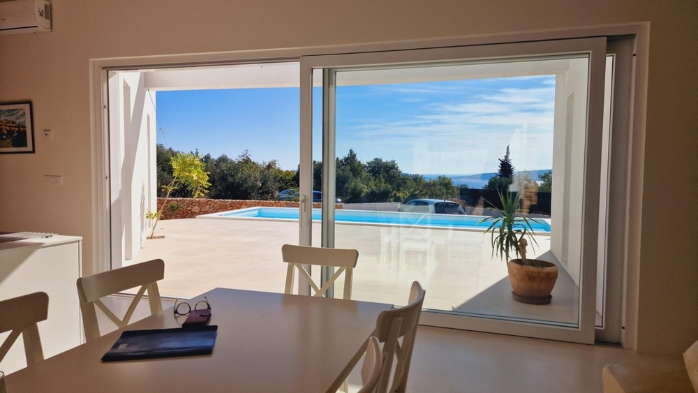 Výhled z obývacího pokoje na terasu a bazén s výhledem na moře