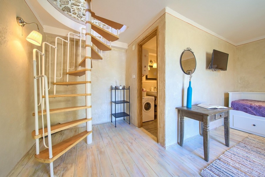 Světlá ložnice s moderním nábytkem a přístupem do koupelny v přízemí.