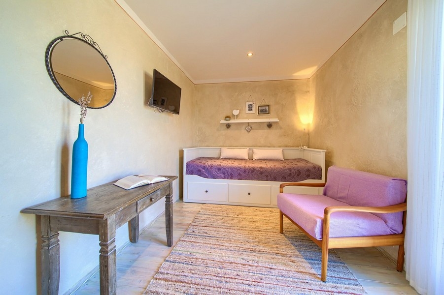 Útulný pokoj s pohovkou v domě H3415, nabízený k prodeji na ostrově Krk, Chorvatsko.