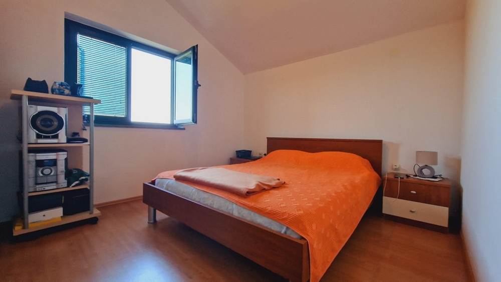 Druhá ložnice s velkou postelí a otevřeným oknem