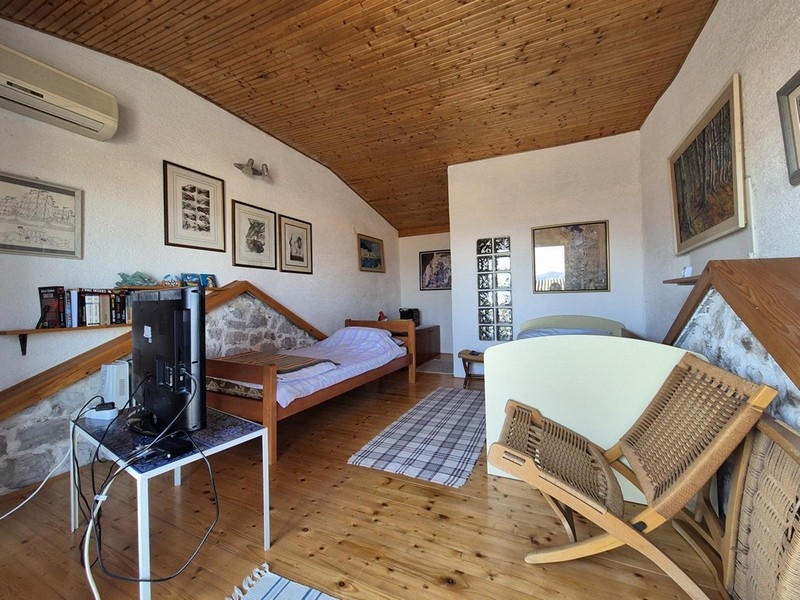 Horní patro s postelí, dřevěným nábytkem a obrázky