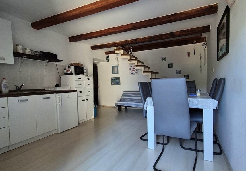 Kuchyň s jídelním stolem a schodištěm do horního patra