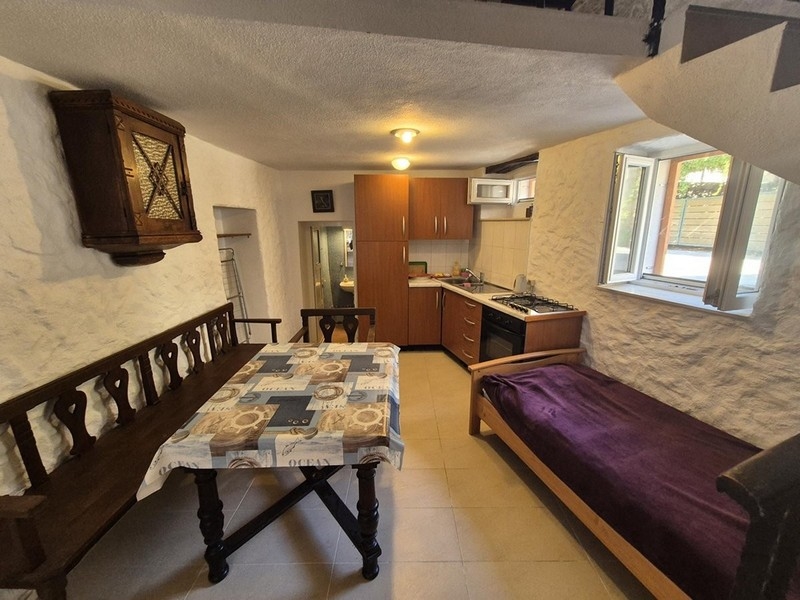 Jídelna a kuchyně s rustikálním nábytkem v přízemí domu.